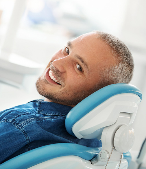 smiling man sitting in a dental chair